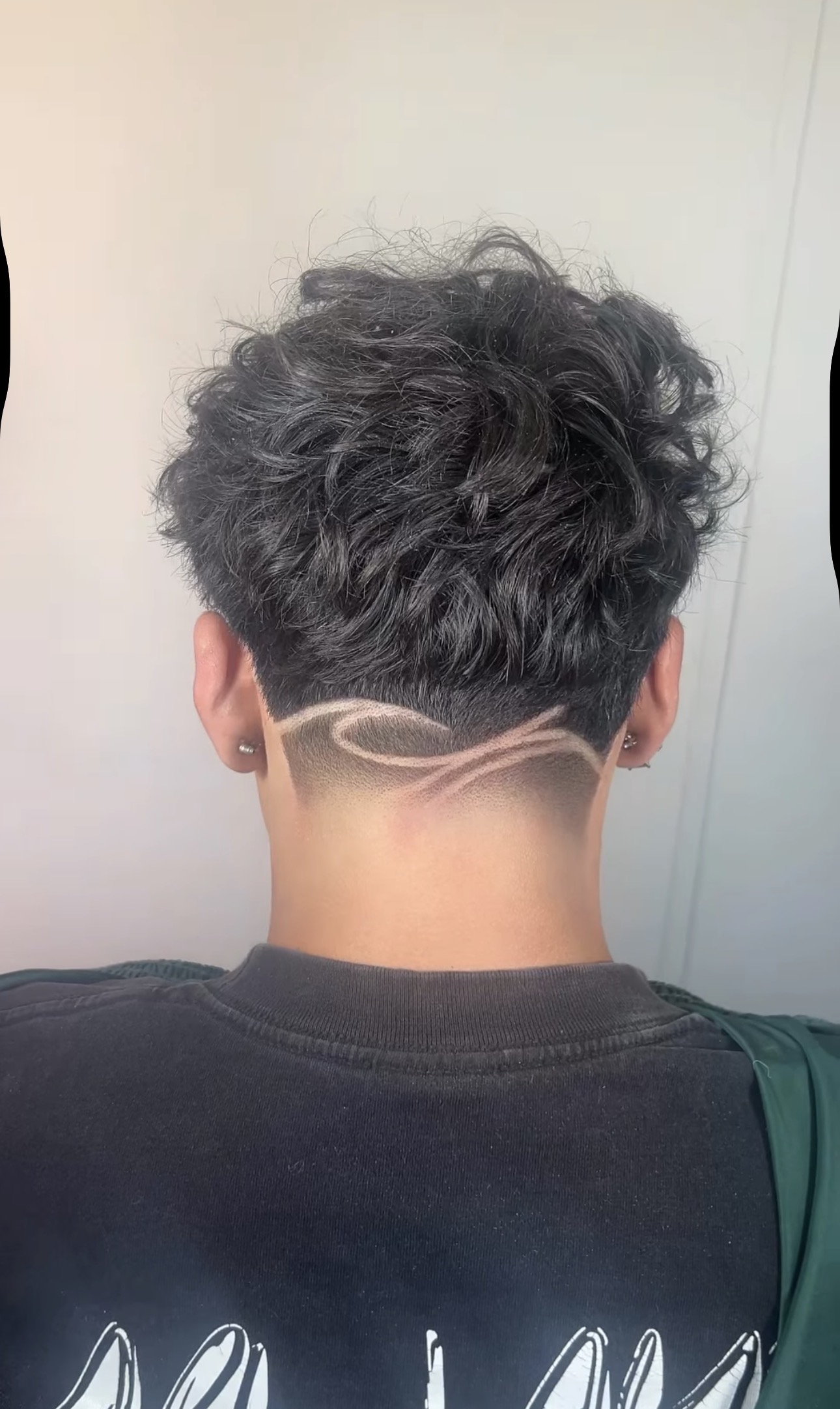 Curly hair with custom wave design shaved in nape